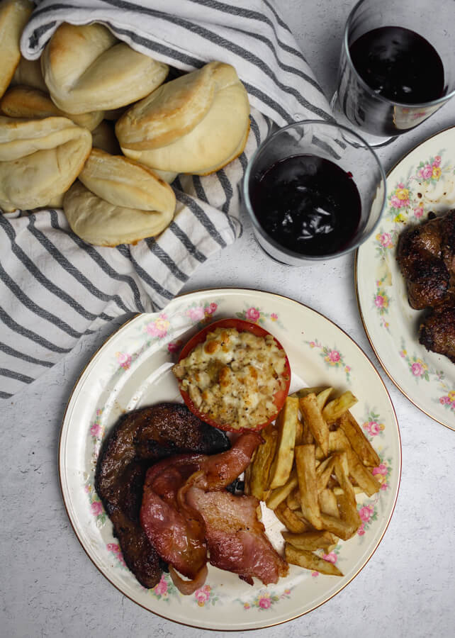 1940s Dinner with liver and bacon, french fries, broiled tomatoes, rolls, and blackberry flummery