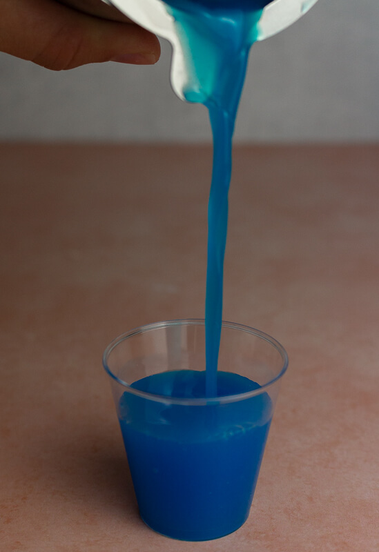 Pouring blue coconut shot into shot glass